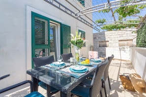 Enjoy a romantic meal for two in this charming outdoor dining area, complete with a glass table, wicker chairs, and beautiful views.