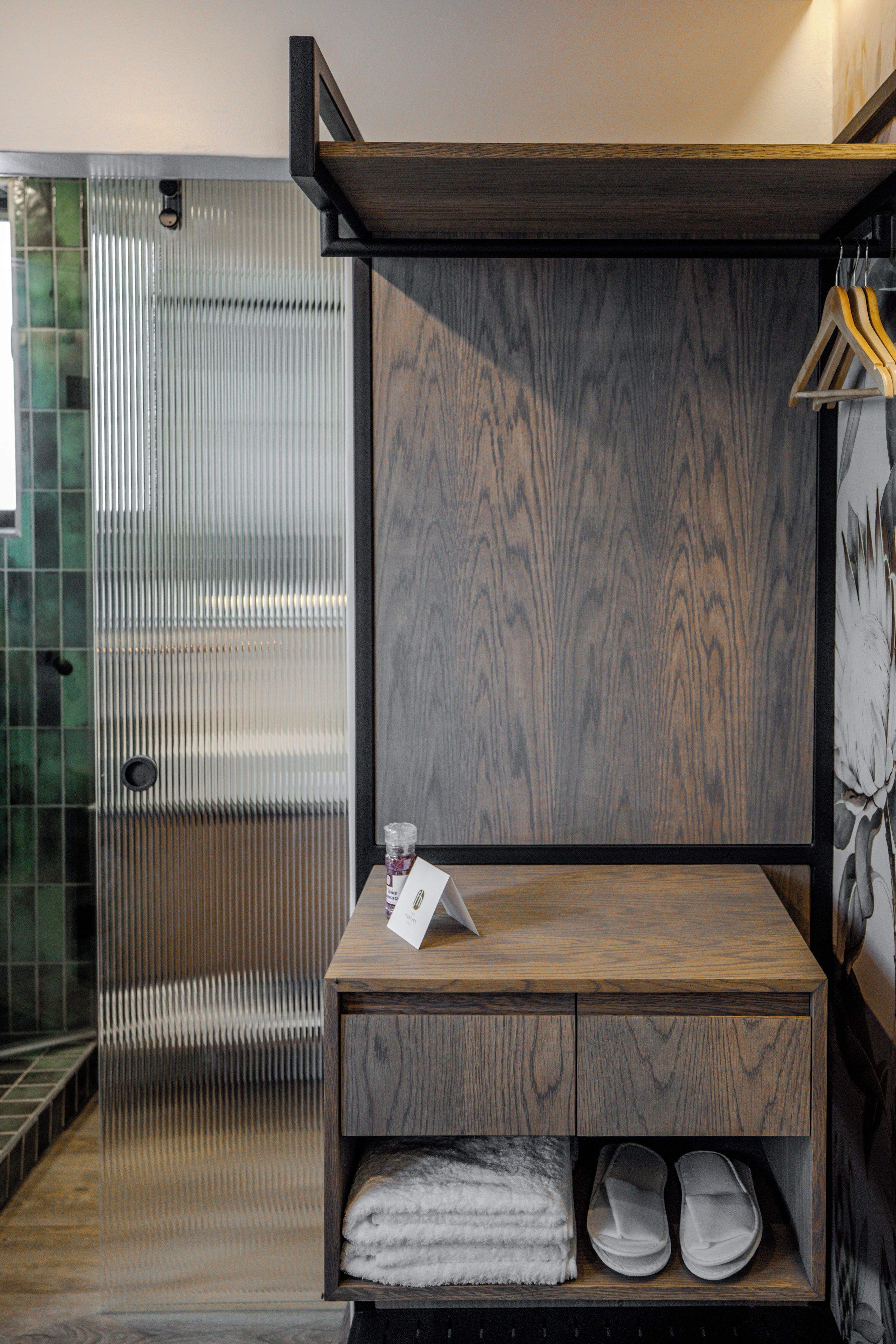 A bathroom with a wooden vanity, a towel rack, and a glass shower enclosure.