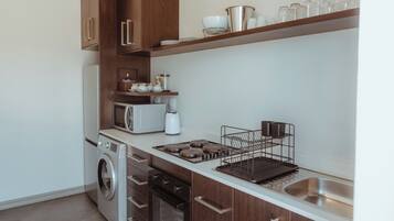 A modern kitchen with wooden cabinets, a stainless steel sink, and a built-in oven.