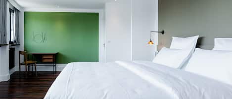 Une chambre d’hôtel moderne, dotée d’un grand lit, d’un bureau et d’une chaise.