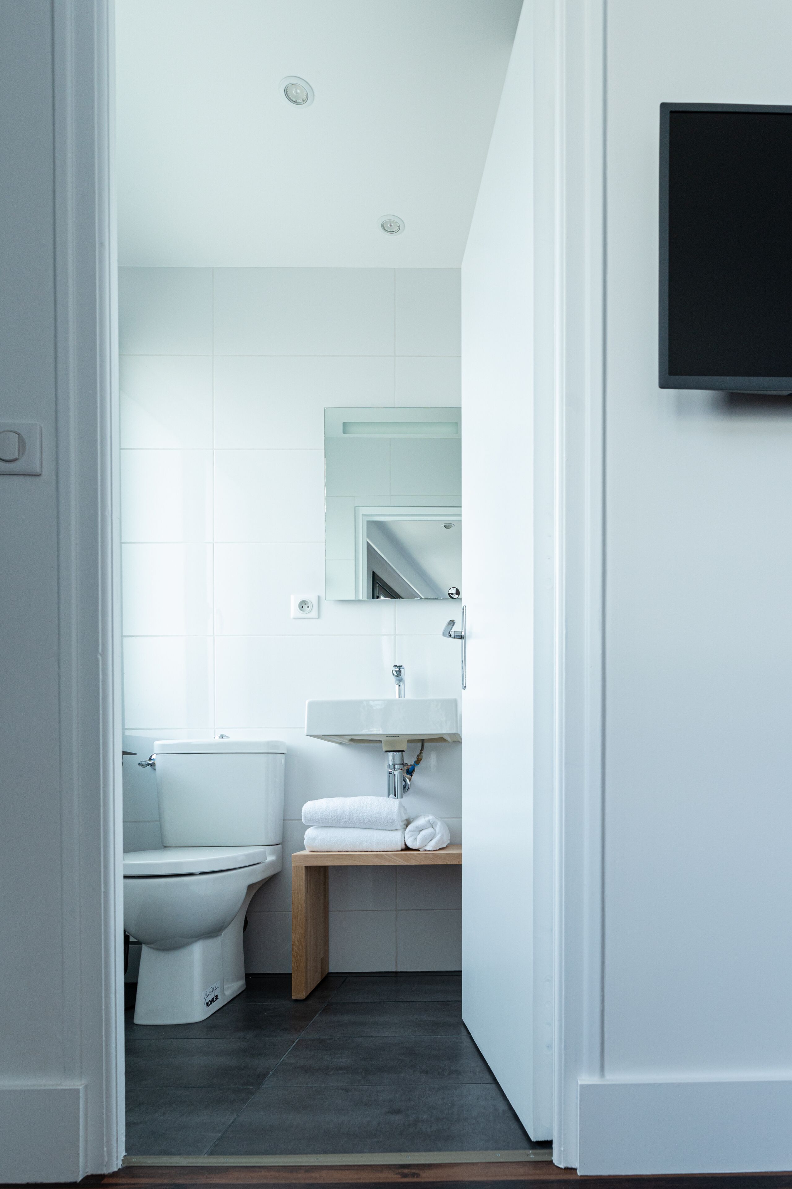 A modern bathroom with a toilet, sink, and mirror.
