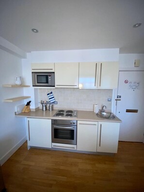 Departamento | Cocina privada | Refrigerador con congelador, microondas, horno y parrilla de estufa 