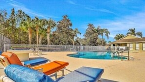 A poolside area with lounge chairs and a pool. - Beautiful 4 Bed, 3.5 Bath Disney pool home. A Perfect family getaway! (Clermont)