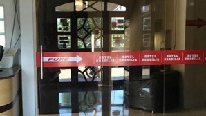 A hotel corridor with directional signs to the Puxi and hotel rooms. - Hotel Brasilia (Buriticupu)