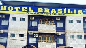 A hotel named "HOTEL BRASÍLIA" with a blue and white facade, multiple air conditioning units, and several parked cars in front. - Hotel Brasilia (Buriticupu)