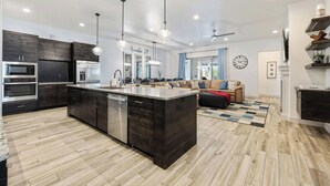 Une cuisine moderne avec des meubles en bois foncé, des appareils électroménagers en acier inoxydable et un grand îlot central.