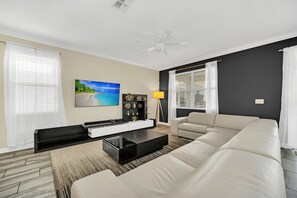 A modern living room with a sofa, a coffee table, a TV, and a decorative shelf.