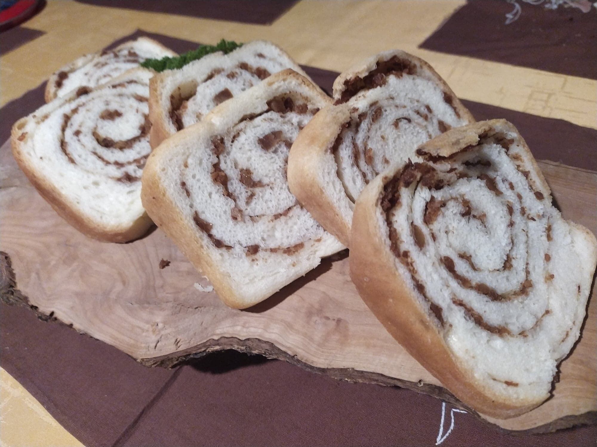 Vier kaneelbroodjes op een houten plank.
