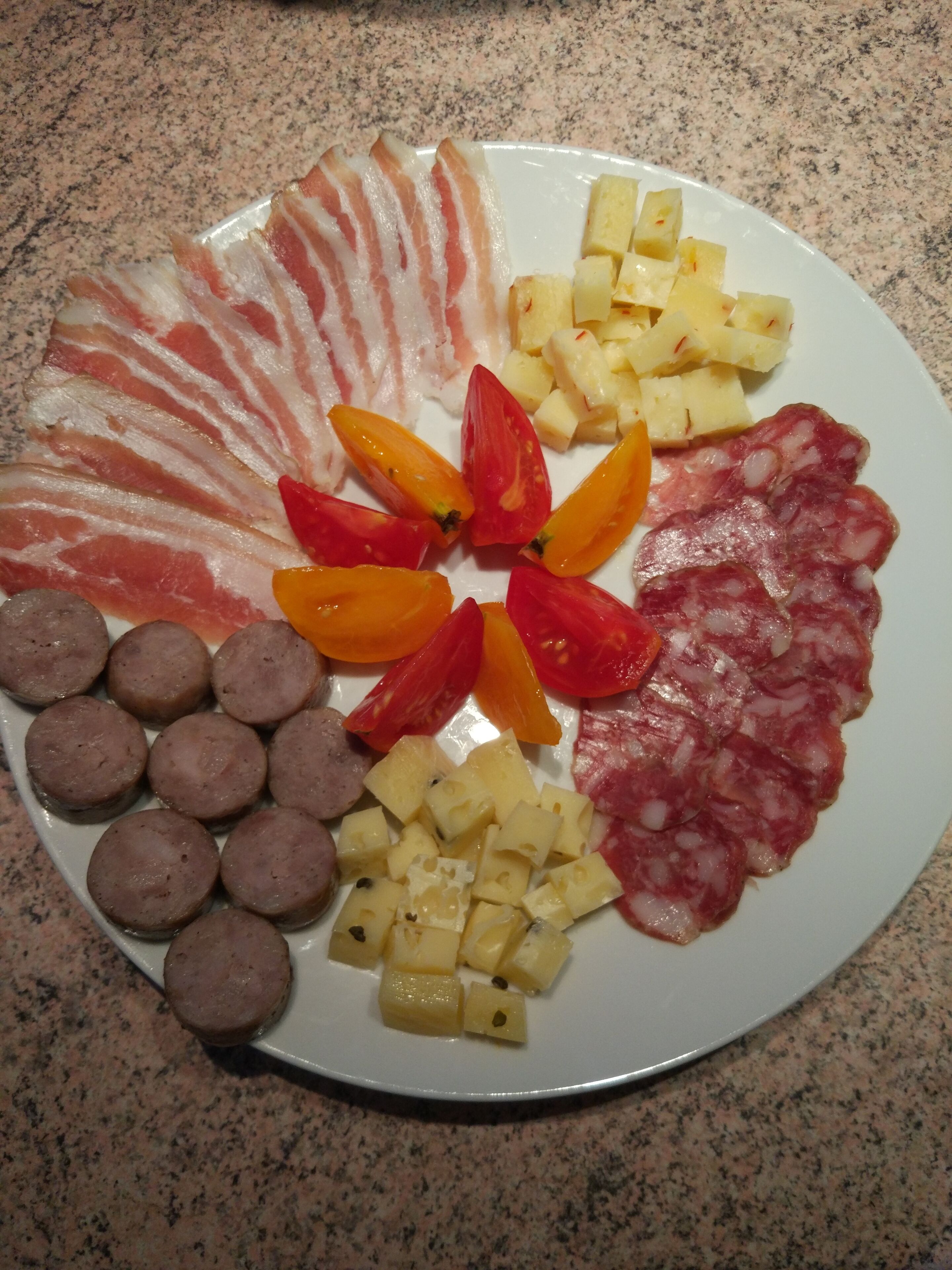 A plate of assorted meats and cheeses.