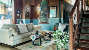 A cozy living room with a sofa, coffee table, and decorative plants.