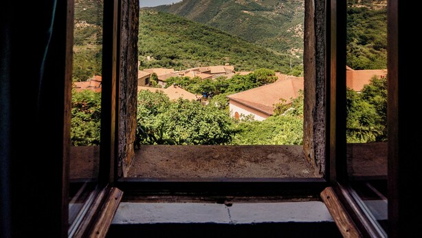 A window with a view of a mountainous landscape and buildings. - Palazzo Mazziotti (Pollica)