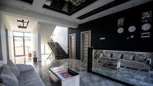Una sala de estar moderna con un sofá, una mesa de centro y un separador de vidrio.