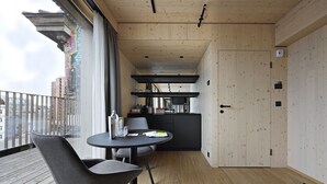 Ein modernes Interieur mit Balkon, Essbereich und Küche.