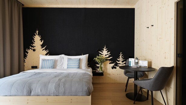 Ein Schlafzimmer mit einem Bett, einem kleinen Tisch und zwei Stühlen.