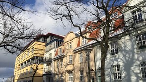 A row of multi-story buildings with balconies, a snow-covered ground, and a clear sky. - 80 m from the beach, everything in view - Anchorage vacation apartment (Rostock-Warnemünde)