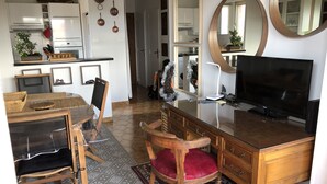 Un espace de vie compact comprenant une cuisine, un coin repas et un téléviseur.