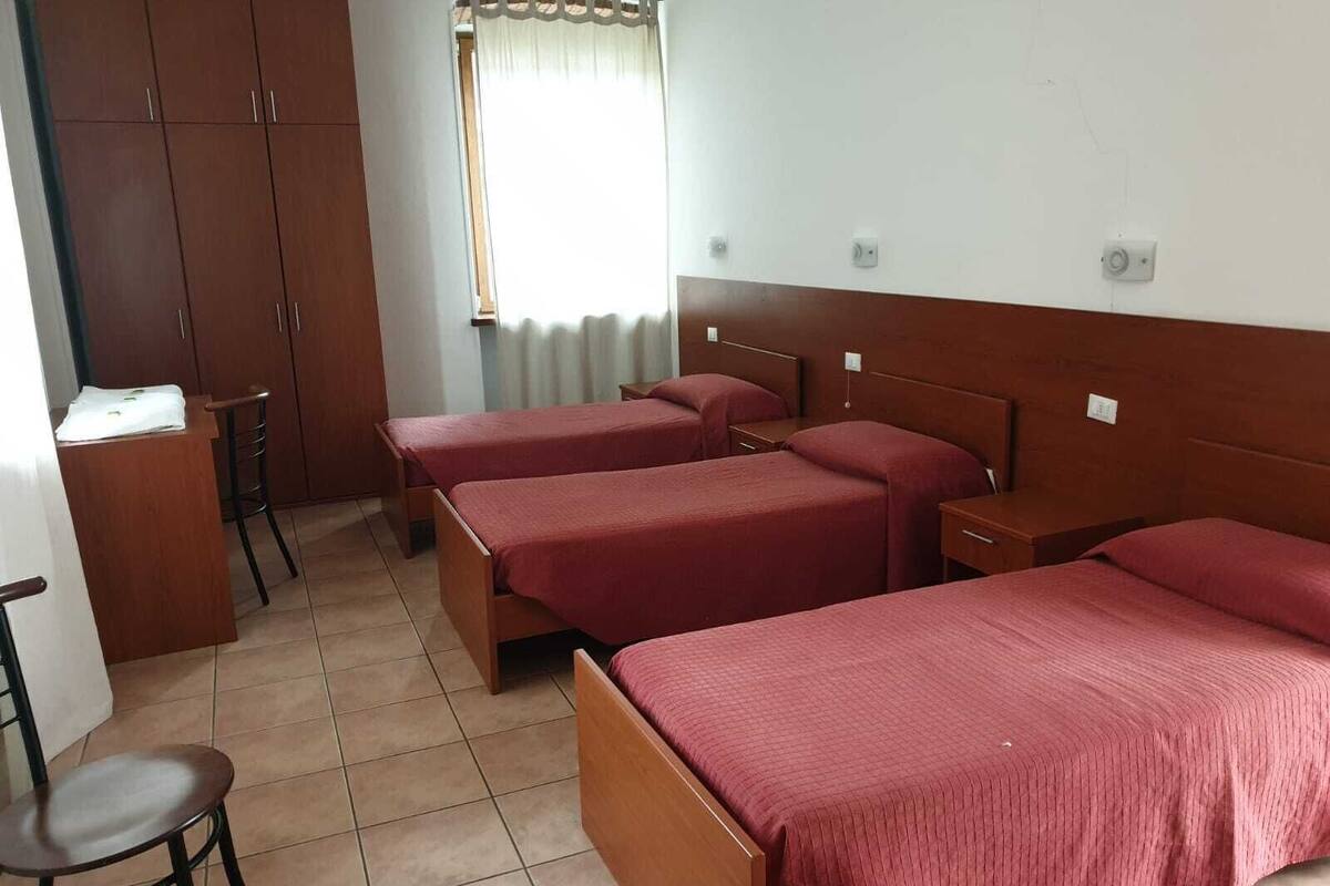 A room with two beds, a desk, and a chair.