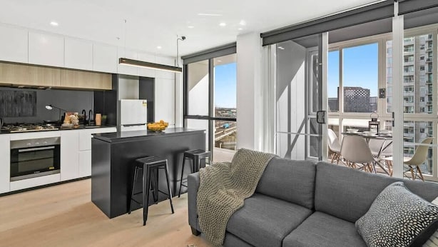 A modern apartment with a kitchen, dining area, and a balcony with a city view. - Declan - Designer Gem *Wi-Fi Views Parking (Southbank)