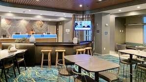 A hotel lobby with a reception desk, bar area, and seating arrangements. - SpringHill Suites by Marriott Cape Canaveral Cocoa Beach (Cape Canaveral)