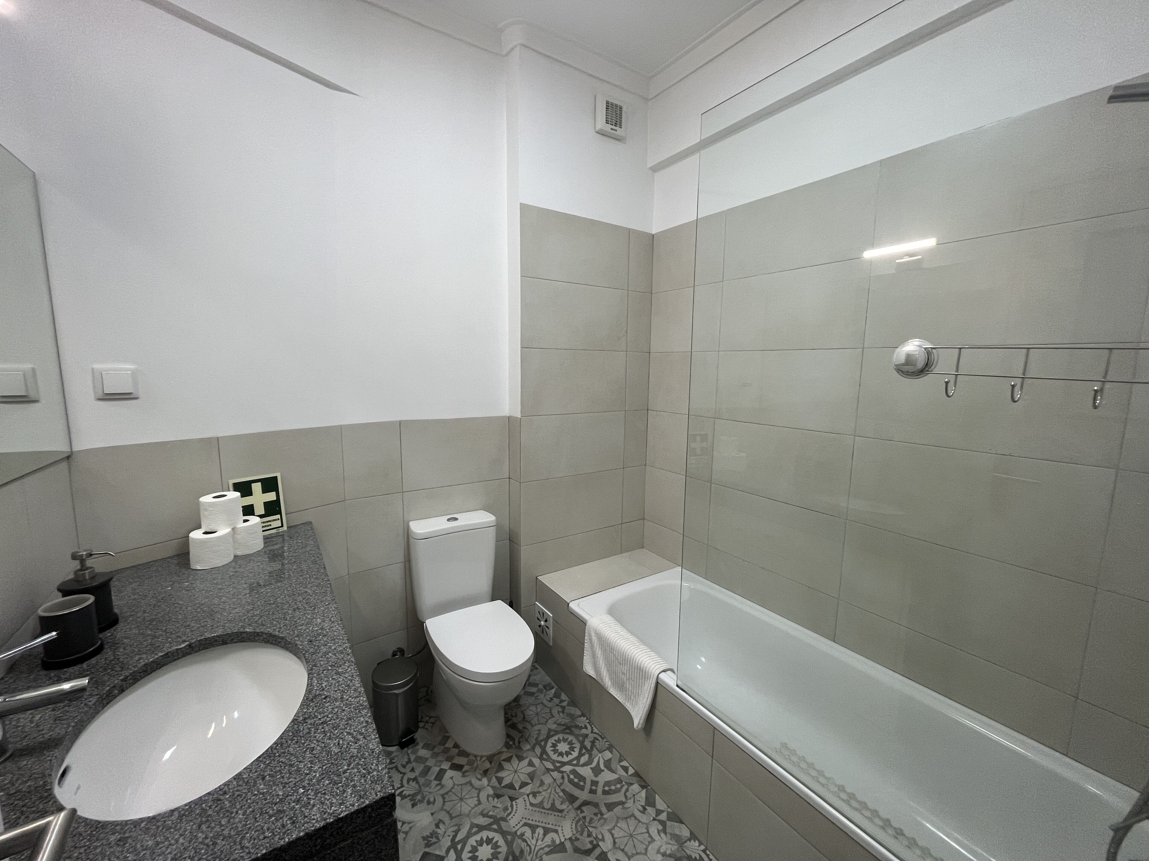 A modern bathroom with a sink, toilet, and bathtub.