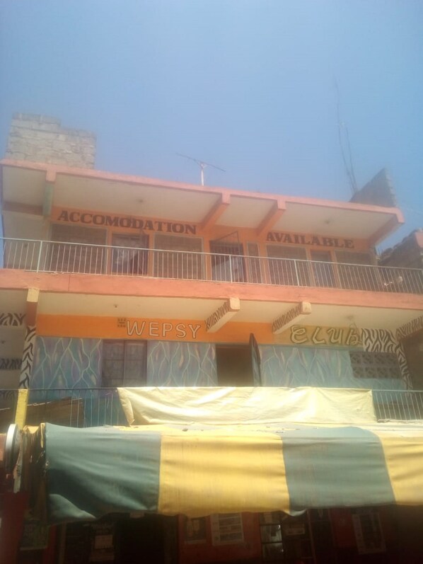 A building with "ACCOMODATION AVAILABLE" signage, a balcony, and a "WEPSY CLUB" sign. - Wespy Guest House (Nairobi)