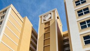 A multi-story building with a central tower featuring a fan-like design. - Luxury Ocean View Condo with Access to No Drive Beach (Daytona Beach Shores)