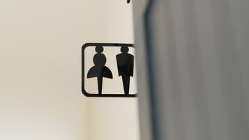 A restroom sign with symbols indicating a men's and a women's restroom.