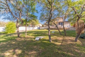 Guests can relax in a serene garden setting surrounded by mature trees and a well-manicured lawn.