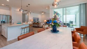 A modern kitchen with a marble island, stainless steel appliances, and pendant lighting. - Brand New Home at Sonoma Resort at Tapestry (Kissimmee)