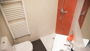 Un baño con inodoro, ducha y lavabo.