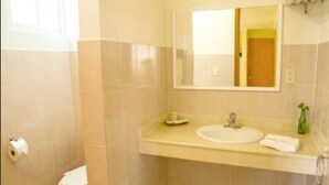 Un baño con inodoro, lavabo y espejo.