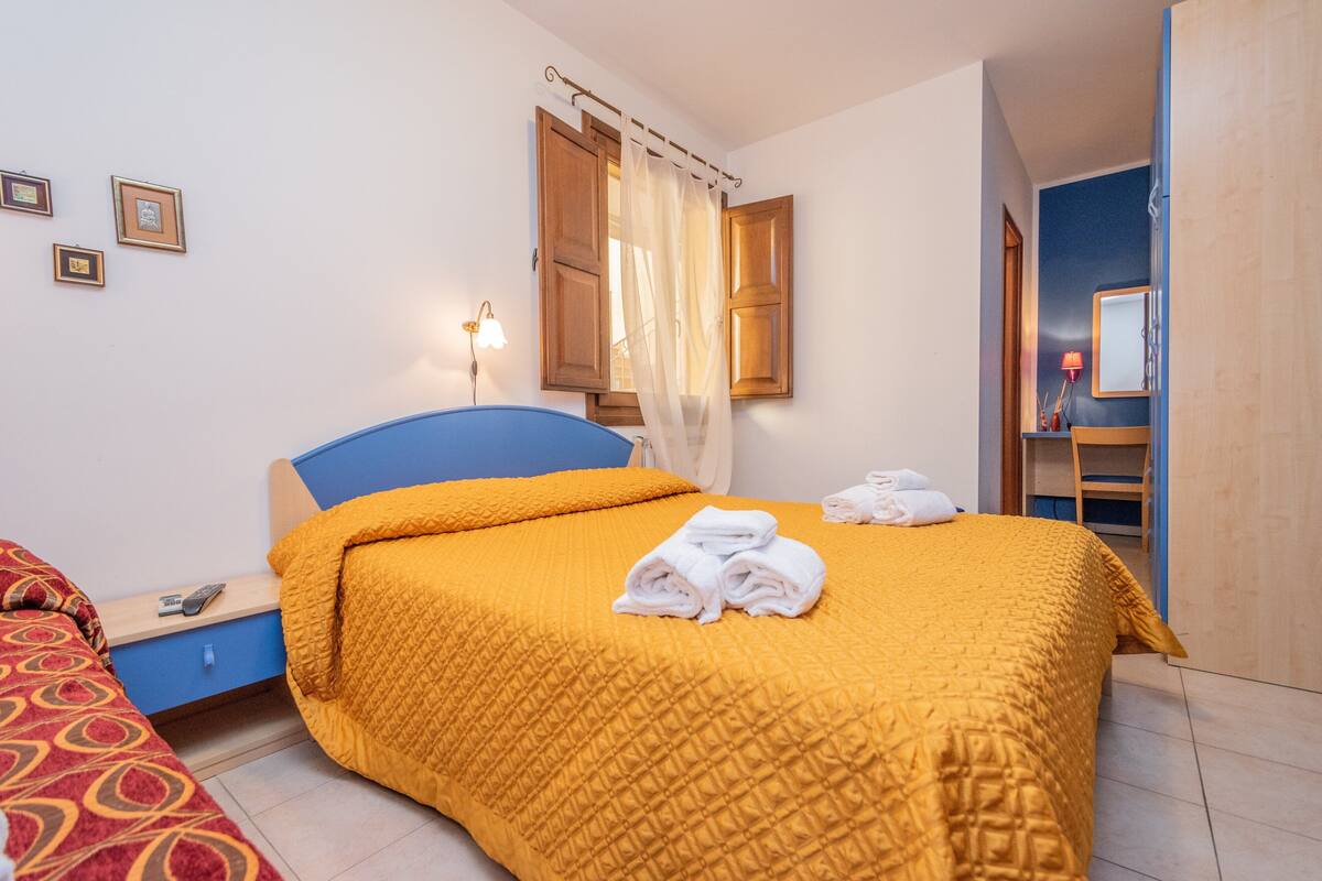 Une chambre à coucher avec un lit, une table de chevet, une lampe et une armoire.