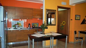 Una cocina con armarios de madera, salpicadero de azulejos y una mesa de comedor con sillas.