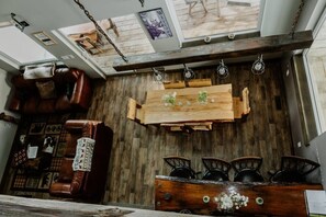 Un interior rústic amb una taula de dinar de fusta, cadires de pell i un armari de fusta amb objectes decoratius.