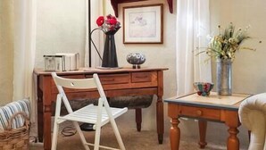 A cozy room with a wooden desk, a white chair, a round table with a tray, and a bookshelf. - Meadowlark Apartment - 10 min to Denver, 1 hr to Mnts/skiing (Lakewood)