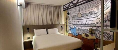 Un dormitorio con cama, mesita de noche, escritorio y silla.