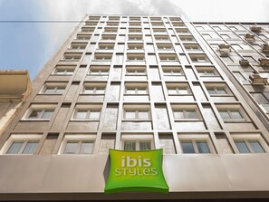 A high-rise building with a prominent green sign reading 'ibis styles' at the ground level. - ibis Styles Buenos Aires Florida (Buenos Aires)