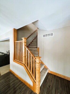 Eine Treppe mit Holzwangen und Teppichstufen, die zu einer oberen Etage führt.
