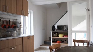 Une cuisine avec des meubles en bois, un four à micro-ondes et un coin repas comprenant une table et des chaises.