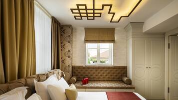 Um quarto com cama, janela com cortinas, um banco embutido e um armário.