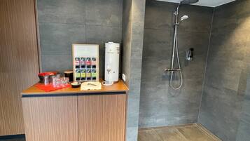 Ein modernes Badezimmer mit Dusche, einem Holzkosmetikschrank und einem Wasserspender.