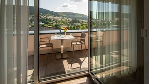 Ein Balkon mit Tisch, Stühlen und Blick auf eine Stadt und Hügel.