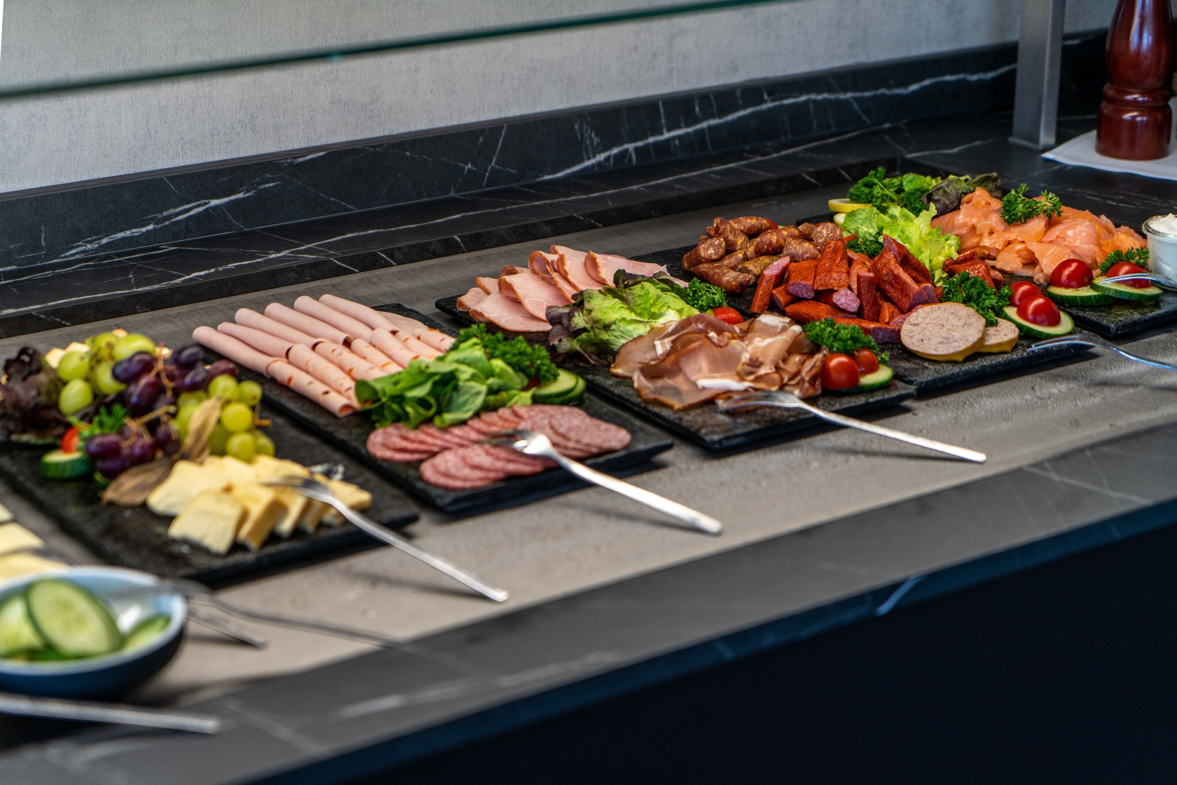 Un buffet proposant une variété de viandes, de fromages et de légumes.