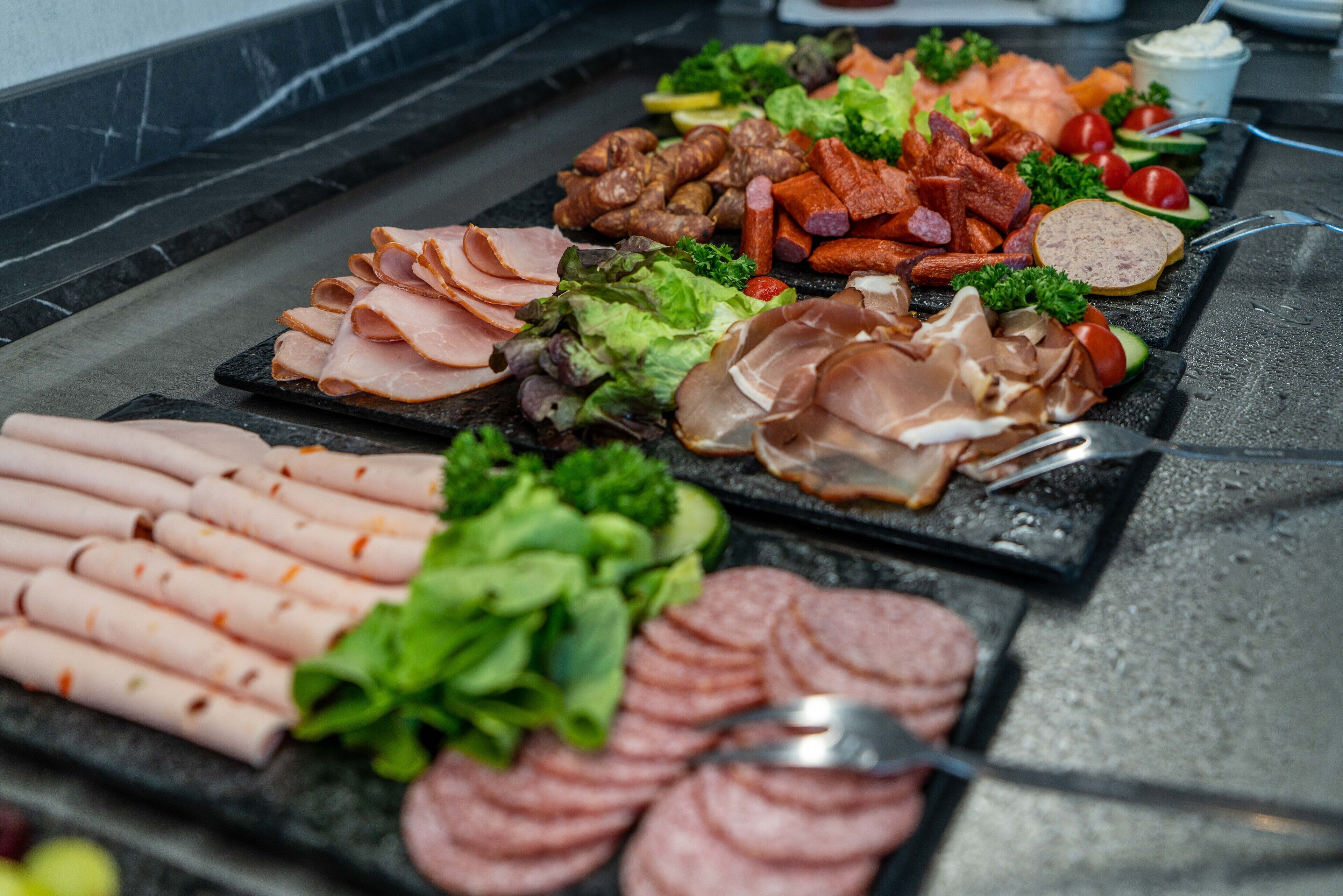 A variety of meats and vegetables arranged on a grill.