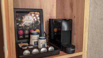A coffee machine and coffee pods on a wooden shelf.