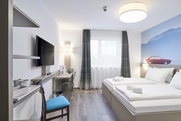 A hotel room with a bed, a desk with a computer, a TV, and a chair. - Best Western Hotel Kiefersfelden (Kiefersfelden)