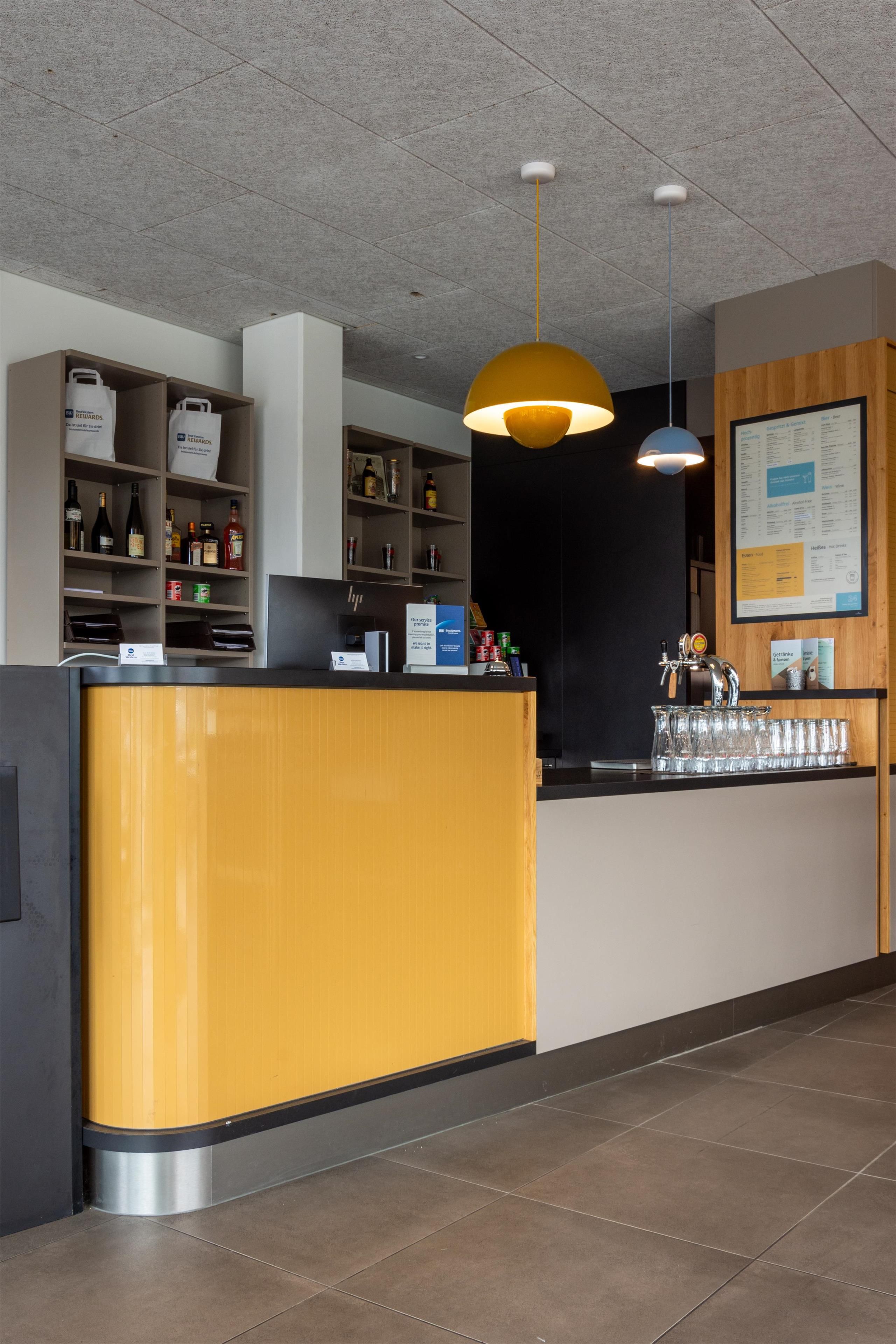 Een receptiebalie met een drankenkast en een menubord.
