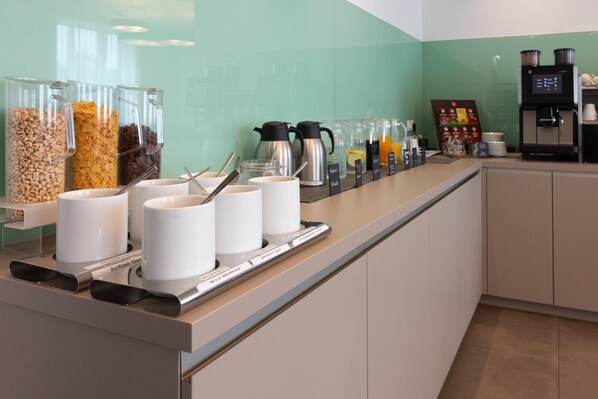A breakfast bar with various food containers, coffee machines, and a coffee station. - Best Western Hotel Kiefersfelden (Kiefersfelden)