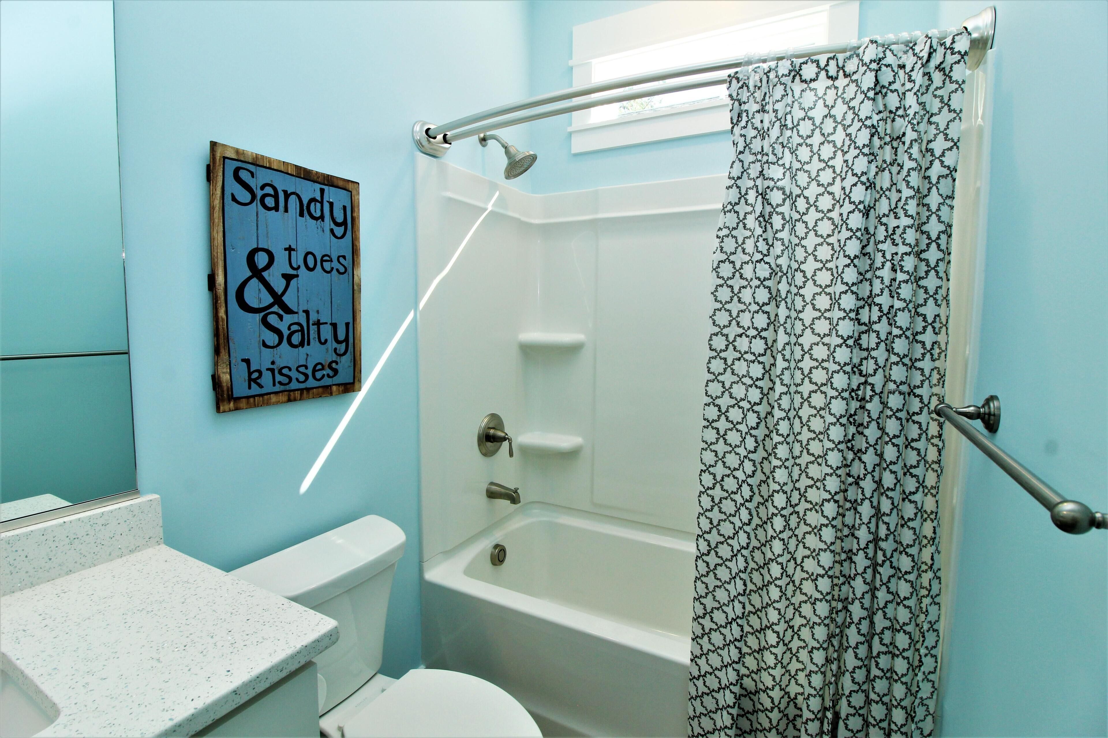A bathroom with a shower, toilet, and a sign on the wall.