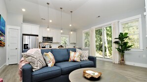 A modern kitchen with white cabinets, stainless steel appliances, and pendant lighting. - Beacon Quarters by KEES Vacations (Corolla)